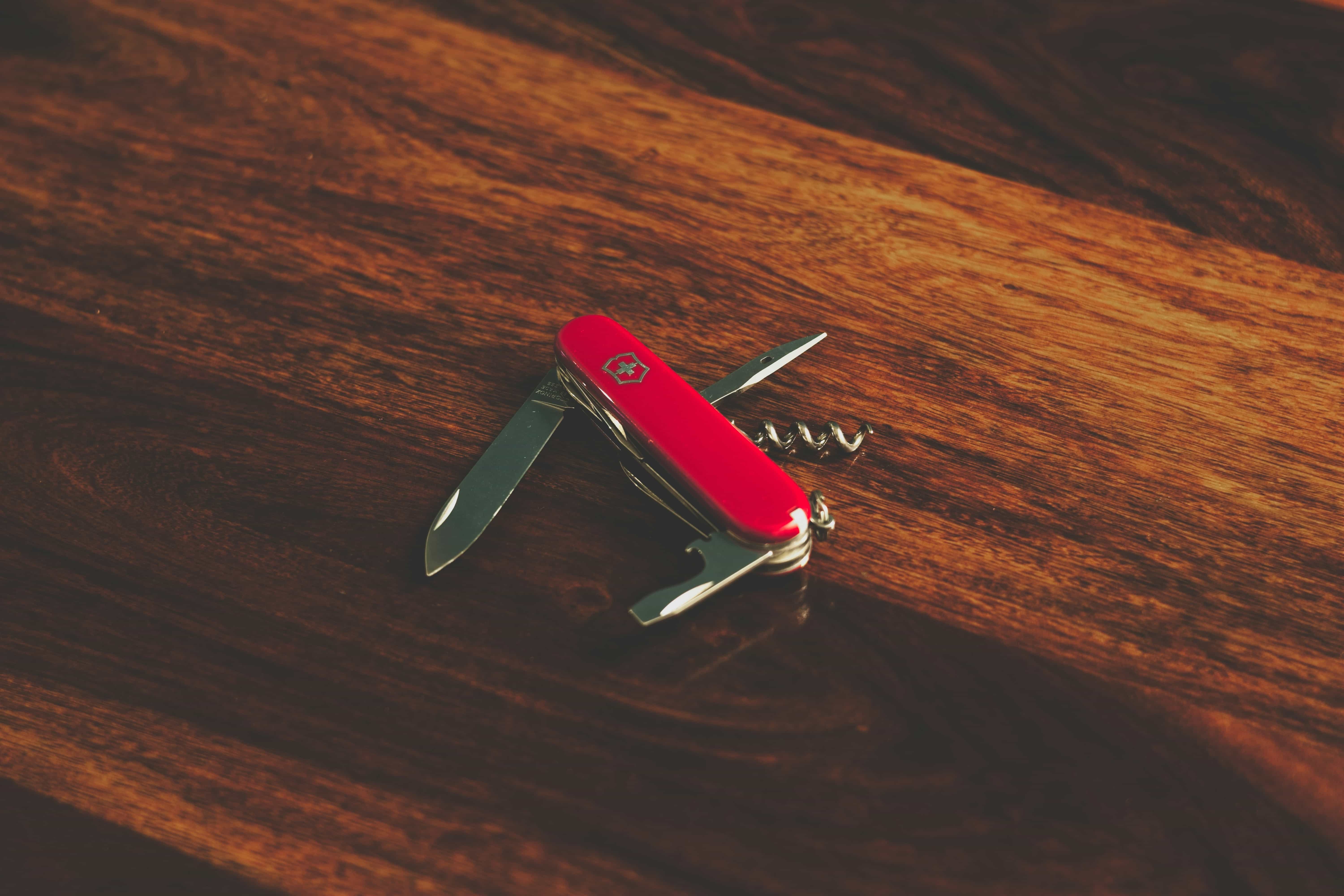 Red Swiss Army knife on a wooden table